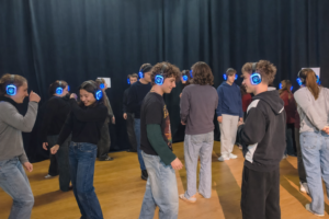 Grupa młodzieży w słuchawkach biorąca udział w interaktywnym przedstawieniu 